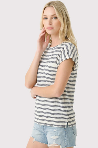 Woman wearing a striped t-shirt and denim shorts on a plain background