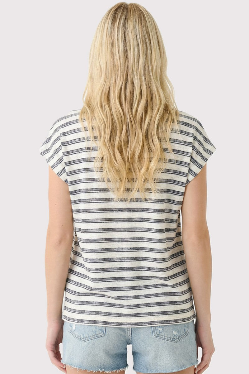 Person wearing a striped sleeveless top and denim shorts on a light background