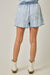 Light blue denim shorts worn by a person on a plain background