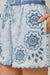 Denim shorts with decorative embroidery on a person's waist.
