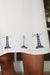 Detail shot of a white dress with black lighthouse and sailboat designs on a blurred background